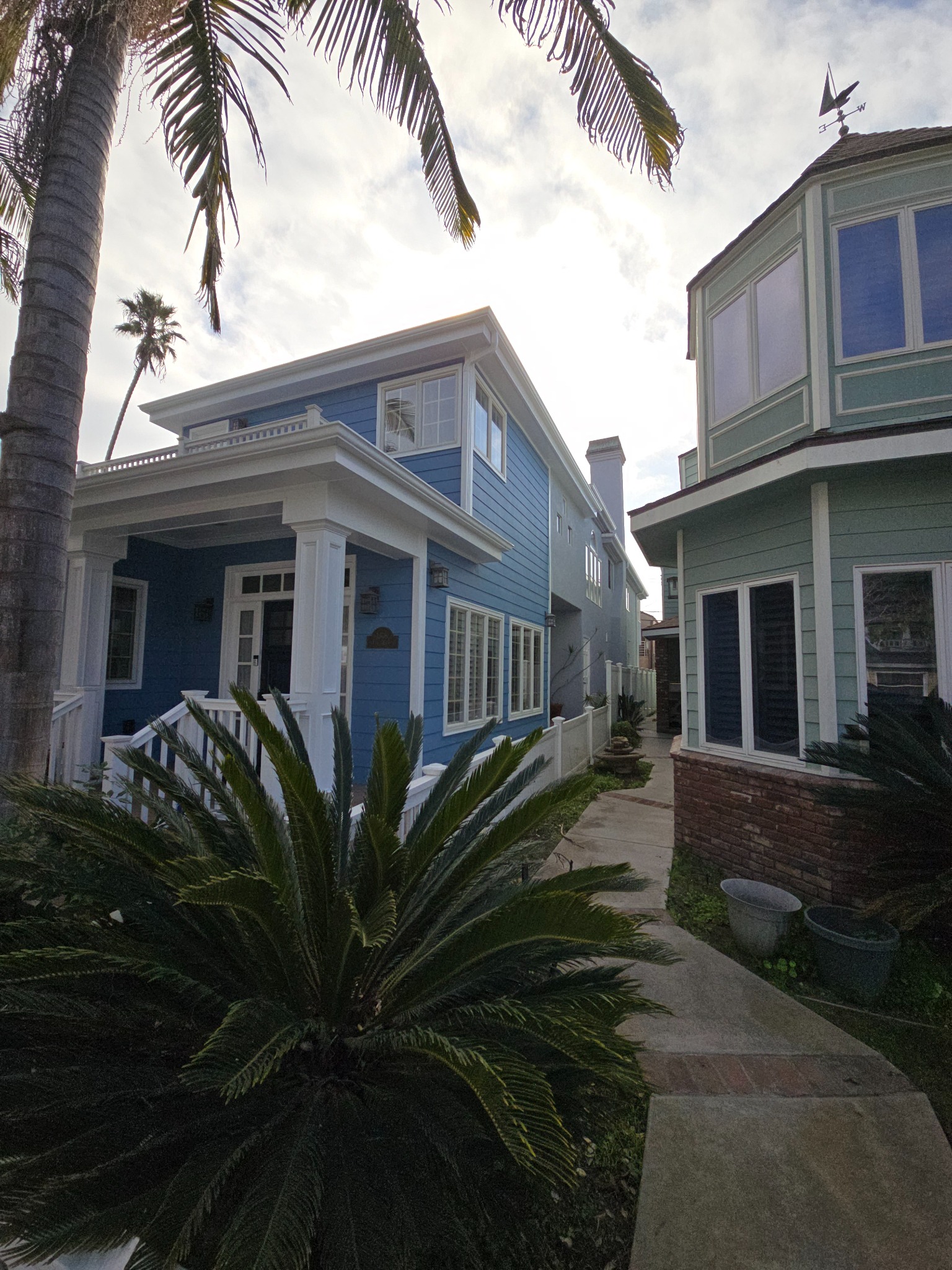 Exterior view of two renovated coastal residences with landscaped grounds